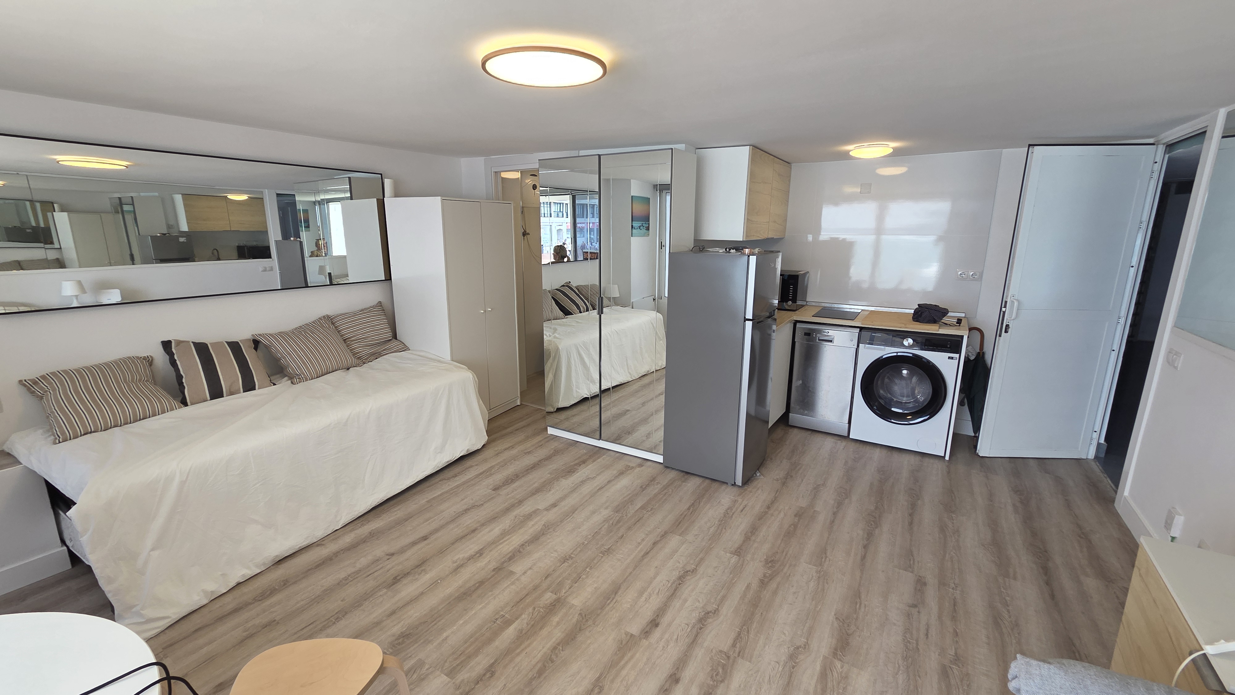 Bright living area with daybed and mirrored wardrobe